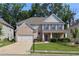 Charming two-story brick home featuring blue shutters, a landscaped yard, and a two-car garage at 1087 Halletts Peak Pl, Lawrenceville, GA 30044