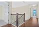 Hallway with hardwood floors and a chandelier viewed from the stairway landing at 1087 Halletts Peak Pl, Lawrenceville, GA 30044