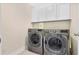Laundry room with front load washer and dryer and white cabinets above at 1087 Halletts Peak Pl, Lawrenceville, GA 30044