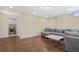 Living room featuring hardwood floors, a sectional sofa, with a laundry room in the background at 1087 Halletts Peak Pl, Lawrenceville, GA 30044