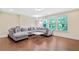 Living room featuring hardwood floors, a sectional sofa, and a window overlooking nature at 1087 Halletts Peak Pl, Lawrenceville, GA 30044