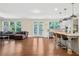 Open concept living space features hardwood floors, modern lighting, and large windows with natural light at 1087 Halletts Peak Pl, Lawrenceville, GA 30044