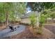 Lush backyard featuring a fire pit area, mature trees, lush plants, and wooden privacy fence at 172 Stoneforest Dr, Woodstock, GA 30189