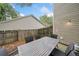 Patio dining set and chairs set with wooden fence, trees, and plants around the perimeter at 172 Stoneforest Dr, Woodstock, GA 30189