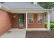 Inviting front porch with brick facade, black door, and two windows at 172 Stoneforest Dr, Woodstock, GA 30189