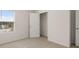 A bright bedroom features neutral carpet, a window view and an open closet space with a white wire shelf at 1910 Van Allen Ct, Dacula, GA 30019
