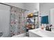 Well-lit bathroom featuring a tub and shower combo with decorative curtains and convenient shelving at 852 Constellation Dr, Decatur, GA 30033