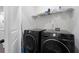 Modern laundry room with front load washer/dryer and wire shelving for storage at 852 Constellation Dr, Decatur, GA 30033