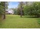 Expansive backyard with lush lawn and treeline. Home with back porch visible at 1054 Foreststone Sw Way, Marietta, GA 30064