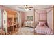 Pink bedroom featuring a dollhouse, four poster bed, and light patterned rug at 1054 Foreststone Sw Way, Marietta, GA 30064