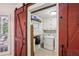 Farmhouse laundry room with red barn door, washer, dryer, and built-in storage at 1054 Foreststone Sw Way, Marietta, GA 30064