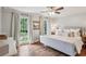 This main bedroom features hardwood floors, neutral walls and curtains, and large windows at 1054 Foreststone Sw Way, Marietta, GA 30064