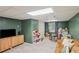 Spacious carpeted playroom with ample storage, play furniture, and natural light at 1054 Foreststone Sw Way, Marietta, GA 30064