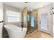 Bright bathroom featuring a modern tub, glass shower, and a window at 3260 Governors Court Ct, Duluth, GA 30096