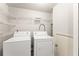 Bright laundry room with washer, dryer, and shelving for organized storage at 3260 Governors Court Ct, Duluth, GA 30096