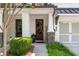 Close-up of home's entrance with a wood door, painted brick, stone accents, and attractive landscaping at 109 Bellehaven Dr, Woodstock, GA 30188