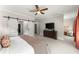 Spacious main bedroom featuring a sliding barn door, ensuite, ceiling fan and an accent chair at 109 Bellehaven Dr, Woodstock, GA 30188