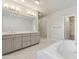 Bright main bathroom with double vanity, soaking tub, and glass enclosed shower at 2058 Glenview Park Cir, Duluth, GA 30097