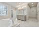 Well-lit main bathroom featuring a soaking tub, double vanity, and glass enclosed shower at 2058 Glenview Park Cir, Duluth, GA 30097