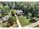 Aerial view of a grand home with a long driveway, lush lawn, and surrounded by mature trees at 7125 Heard Rd, Cumming, GA 30041
