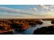 Aerial view of lake with docks and colorful fall trees at sunset, providing scenic beauty at 7125 Heard Rd, Cumming, GA 30041