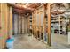 Partially finished basement with exposed framing, concrete floors, and storage shelves in the background at 7125 Heard Rd, Cumming, GA 30041