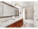 Bathroom featuring double sinks, quartz countertops, a large mirror, and a tub/shower combo at 7125 Heard Rd, Cumming, GA 30041