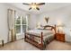Cozy bedroom with a ceiling fan, a decorative quilt, and natural light from the window at 7125 Heard Rd, Cumming, GA 30041