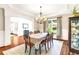 Elegant dining room features hardwood floors, a chandelier, and views of the outdoors at 7125 Heard Rd, Cumming, GA 30041