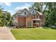 Stately brick and siding home with manicured lawn, charming landscaping, and a welcoming entrance at 7125 Heard Rd, Cumming, GA 30041