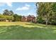 Sprawling estate featuring a well-manicured lawn, mature trees, and a grand, inviting facade at 7125 Heard Rd, Cumming, GA 30041