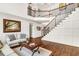 Welcoming foyer featuring hardwood floors, a staircase with iron spindles, and stylish decor at 7125 Heard Rd, Cumming, GA 30041