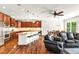 Open-concept kitchen and living area with an island, stainless steel appliances, and cherry cabinets at 7125 Heard Rd, Cumming, GA 30041