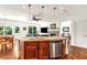 Open-concept kitchen with granite countertops, stainless steel appliances, and island seating, connecting to the living and dining areas at 7125 Heard Rd, Cumming, GA 30041