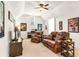 Cozy living room with plush leather seating, a ceiling fan, a piano, and carpet flooring at 7125 Heard Rd, Cumming, GA 30041