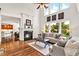 Bright living room with a fireplace, hardwood floors, and large windows overlooking the yard at 7125 Heard Rd, Cumming, GA 30041