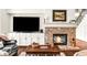 Living room featuring a stone fireplace, built-in cabinets, and a large television screen at 7125 Heard Rd, Cumming, GA 30041