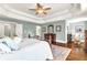 Charming primary bedroom featuring hardwood floors, tray ceilings, a decorative area rug, and ample natural light at 7125 Heard Rd, Cumming, GA 30041