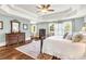Relaxing primary bedroom with tray ceilings, hardwood floors, and large windows providing ample natural light at 7125 Heard Rd, Cumming, GA 30041