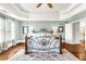 Elegant main bedroom featuring hardwood floors, tray ceilings, and a wrought-iron bed frame at 7125 Heard Rd, Cumming, GA 30041