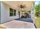 Covered back patio featuring a ceiling fan and access to the backyard with stairs leading to the upper level at 7125 Heard Rd, Cumming, GA 30041