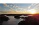 Scenic sunset over the lake, showcasing tranquil waters and lush forested shores at 7125 Heard Rd, Cumming, GA 30041