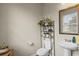 Cozy half-bathroom featuring a pedestal sink, decorative mirror, and wall decorations at 8553 Braylen Manor Dr, Douglasville, GA 30134