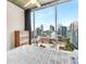 Bedroom with a large window view of the city skyline, concrete ceiling, and wood floors at 860 Peachtree Ne St # 2001, Atlanta, GA 30308