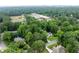 Aerial view showcasing a home nestled among lush trees and nearby school with athletic fields at 5070 Hensley Dr, Atlanta, GA 30338