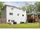 Expansive backyard with a covered deck, lush green lawn, and white painted brick house at 5070 Hensley Dr, Atlanta, GA 30338