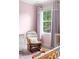 Charming Bedroom with pink walls, rocking chair, white dresser, and window with sheer curtains at 5070 Hensley Dr, Atlanta, GA 30338