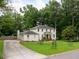 Well-maintained white brick home with a lush green lawn, long driveway, and mature trees at 5070 Hensley Dr, Atlanta, GA 30338