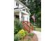 Inviting home featuring a charming front porch with wood stairs, a green lawn, and beautiful shrubbery at 5070 Hensley Dr, Atlanta, GA 30338
