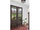 Elegant double front doors with glass panes, a patterned rug, and view of the landscaped yard at 5070 Hensley Dr, Atlanta, GA 30338